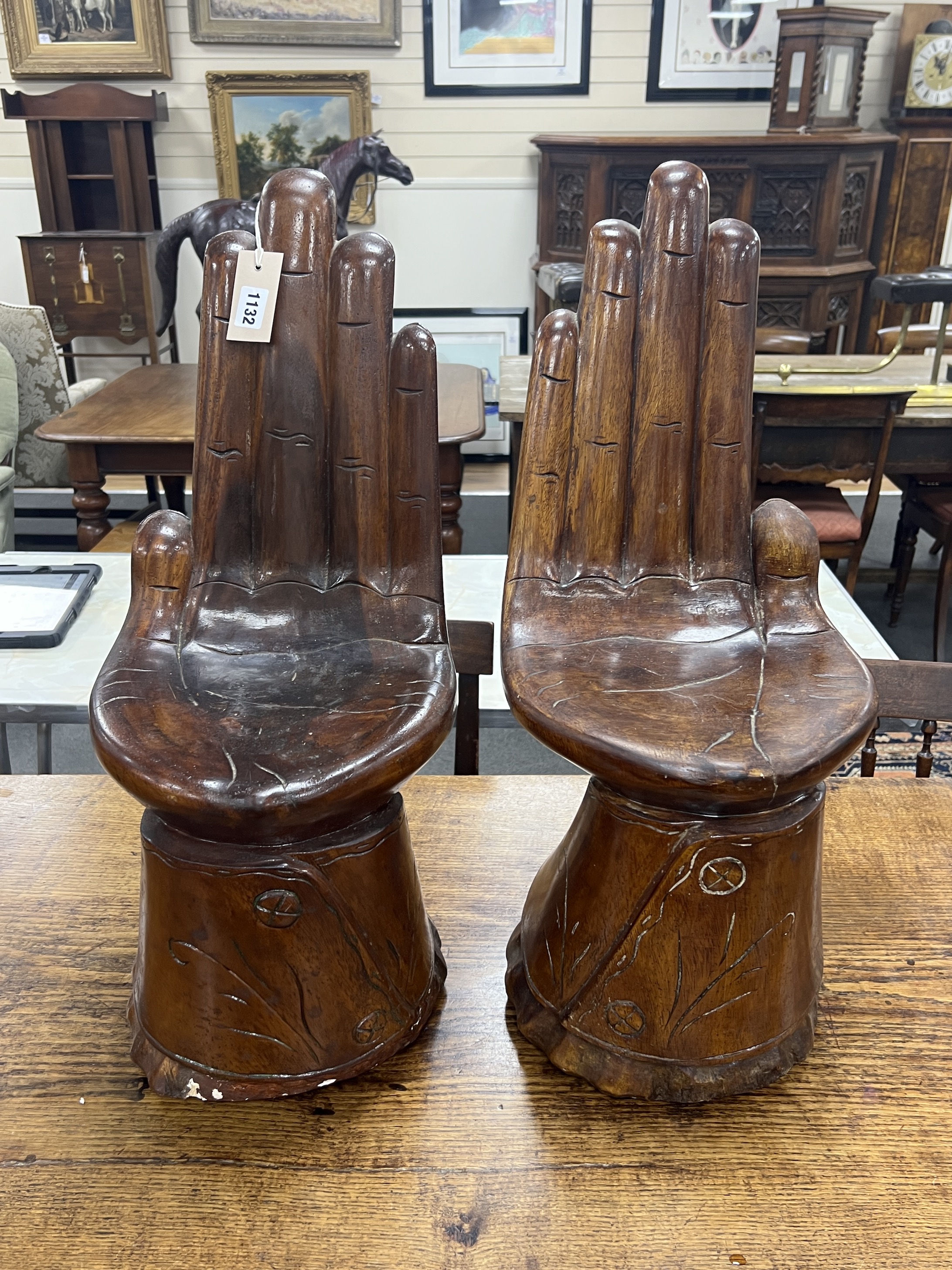 A pair of Eastern carved hardwood stools modelled as hands, height 66cm
